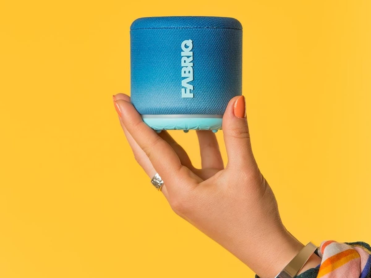 FABRIQ fabric-wrapped smart speaker held in one hand