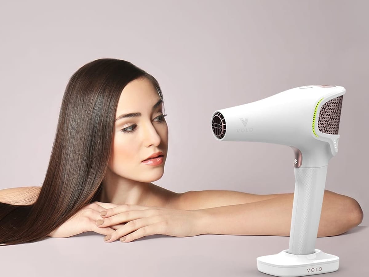 VOLO GO cordless hairdryer beside a model with long hair